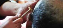 خانمی که با پاهایش موهای همسرش را کوتاه می کند (عکس)
